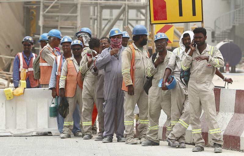 DUBAI , UNITED ARAB EMIRATES , JULY 30 – 2018 :- Labourers waiting for their staff bus during the dusty and hot weather in Discovery Gardens area in Dubai. ( Pawan Singh / The National )  For News.