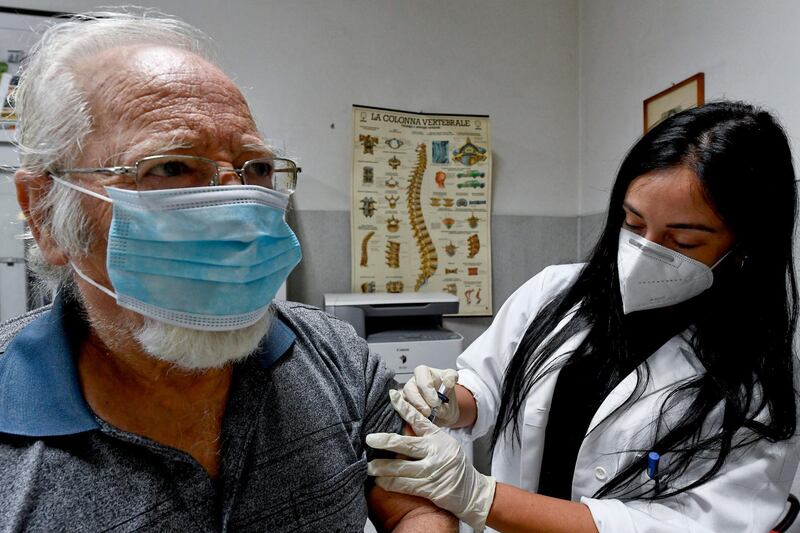 A doctor administers a flu vaccine to a patient in Naples, Italy, October 7. Ciro Fusco / EPA