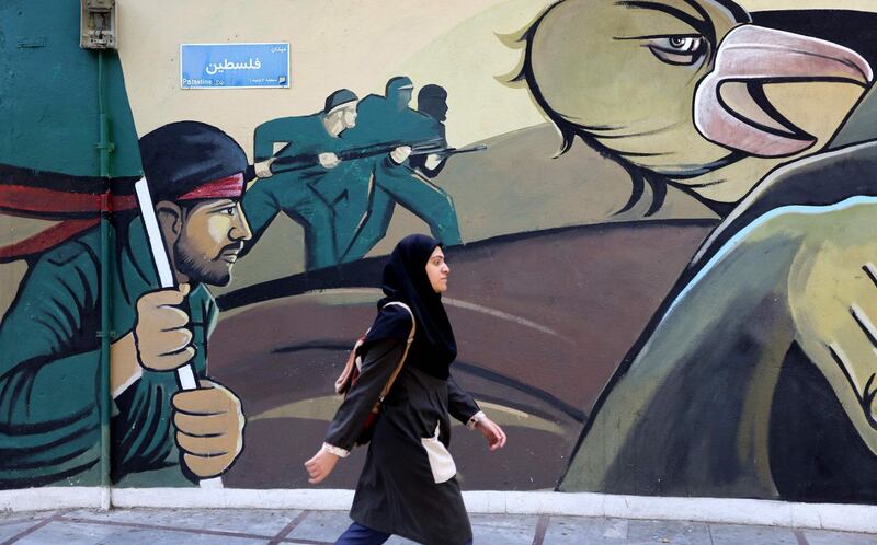 A woman walks past a mural painting on Palestine Square in the Iranian capital Tehran.  AFP
