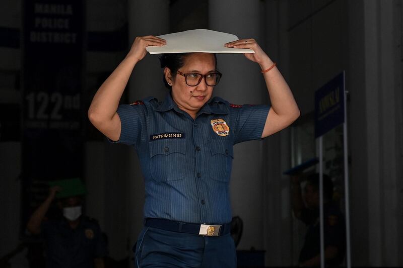 A policewoman leaves a building in Manila after the quake struck. AFP