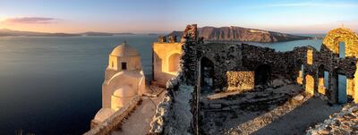 [UNVERIFIED CONTENT] The picture captures the red and orange sunrise  in OIA Santorin, also named Thira. The view outreaches over the old castle, built onto the caldera. The castle dipped in beautiful warm and soft morning light - the wall leads you into the panoramic picture.
In the background the blue calm sea and the volcano island.