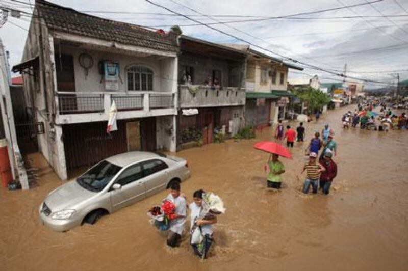 Residents wade through floodwaters brought about by typhoon Mirinae on Saturday, October 31, 2009.