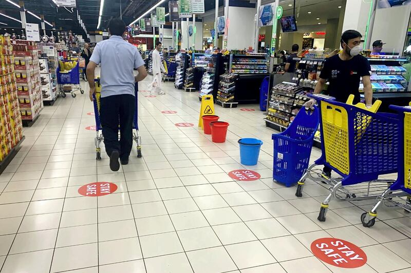 This picture taken on March 22, 2020 in Dubai shows a view of distance stickers reading "stay safe" placed along aisles at a supermarket, marking safe distances for shoppers to facilitate "social distancing" methods as part of safety measures during the COVID-19 coronavirus pandemic.  / AFP / KARIM SAHIB
