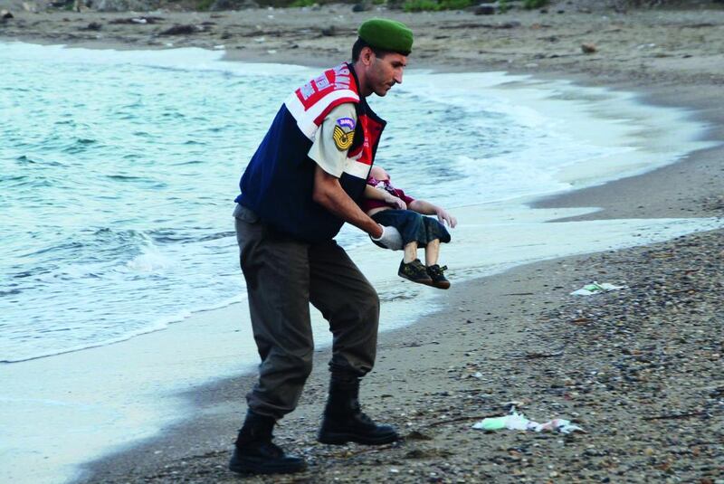 A Turkish gendarmerie carries a young migrant, who drowned in a failed attempt to sail to the Greek island of Kos, in the coastal town of Bodrum, Turkey on September 2. At least 11 migrants believed to be Syrians drowned as two boats sank after leaving southwest Turkey for the Greek island of Kos, Turkey’s Dogan news agency reported on Wednesday. Reuters / Nilufer Demir / DHA