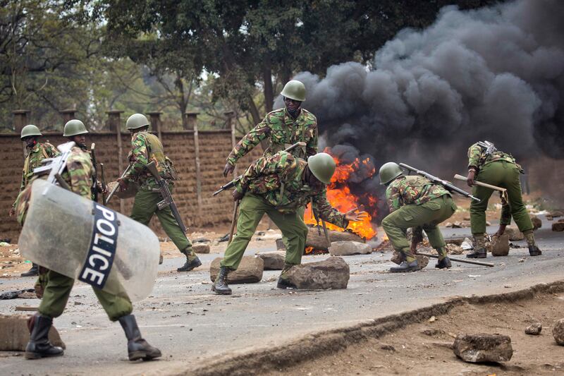 Kenyan security forces remove stones from a street blocked by supporters of Kenyan opposition leader and presidential candidate Raila Odinga who demonstrated in the Mathare area of Nairobi. Jerome Delay / AP Photo