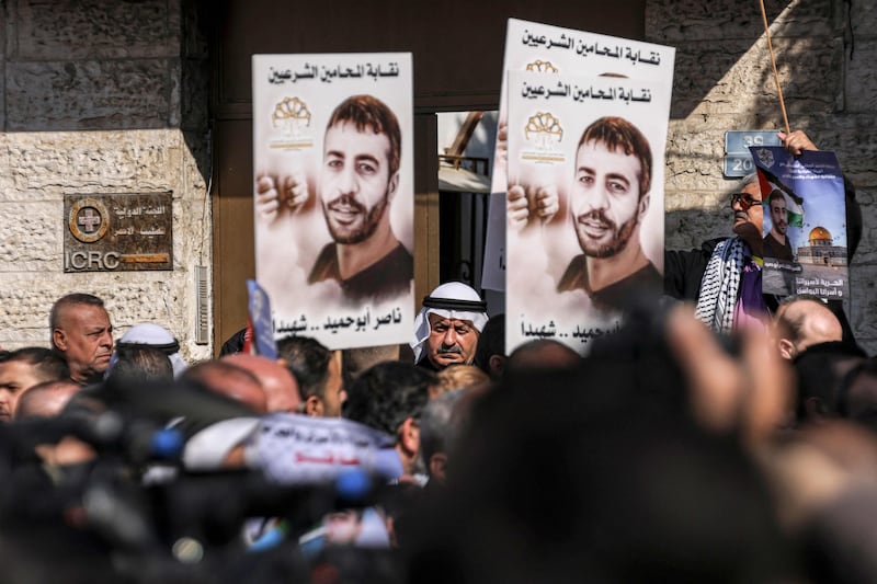 Protesters with photos of Palestinian Nasser Abu Hamid outside Red Cross headquarters in Gaza City. AFP