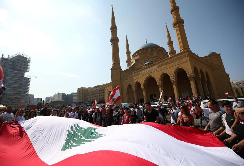 Demonstrators hold a Lebanese flag during an anti-government protest in downtown Beirut, Lebanon. Reuters