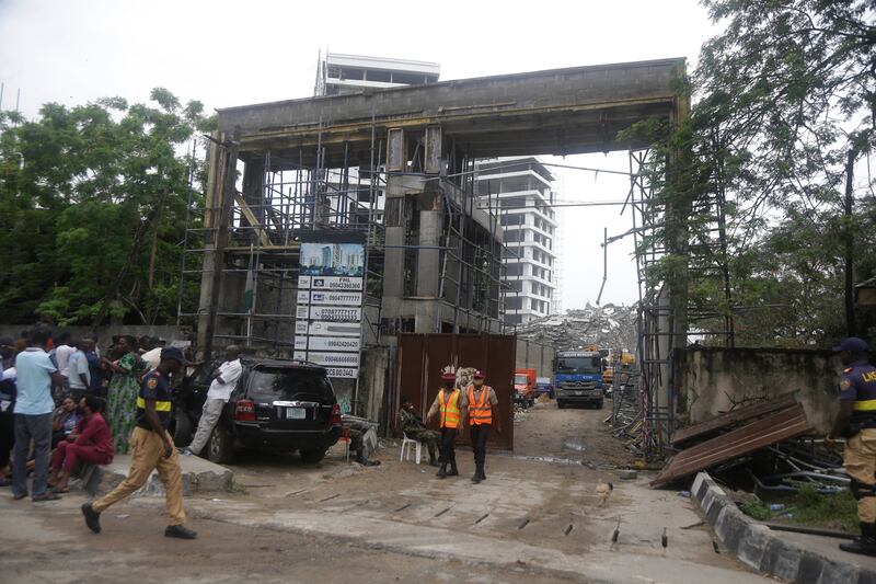 Rescue workers at the site of the collapsed 21-story apartment building under construction in Lagos.  AP