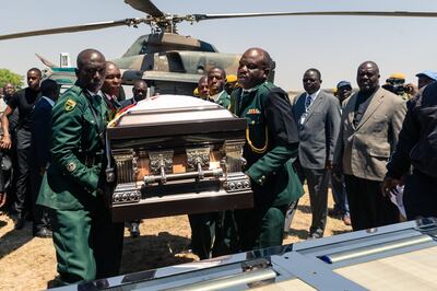 Members of the presidential guard transfer the coffin bearing the remains of late former Zimbabwean president Robert Mugabe to a hearse upon arrival by helicopter at his Kutama village residence, Zimbabwe, on September 16, 2019. The remains of former Zimbabwe president Robert Mugabe were taken to his village for a wake on September 16, a family member said, as his final burial is prepared in about a month. Mugabe died a week ago aged 95 in Singapore, nearly two years after he was ousted in a 2017 coup that ended nearly four decades of increasingly autocratic rule. After a state funeral on September 14 in the capital Harare attended by African leaders, his body went to his rural village of Kutama, 90 kilometres (55 miles) to the west, to allow villagers to pay tribute and bid farewell. / AFP / Jekesai NJIKIZANA
