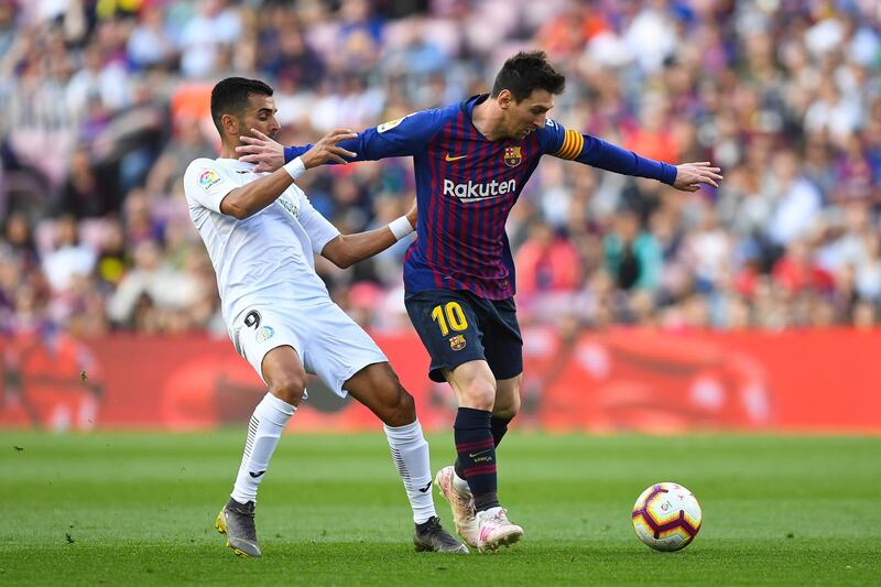 Lionel Messi holds off a challenge from Angel Gavilan. Getty Images