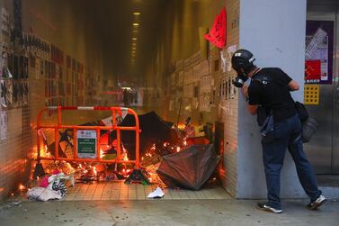 An anti-government protester at a burning barricade on during a Global Anti-Totalitarianism Rally in Hong Kong. EPA