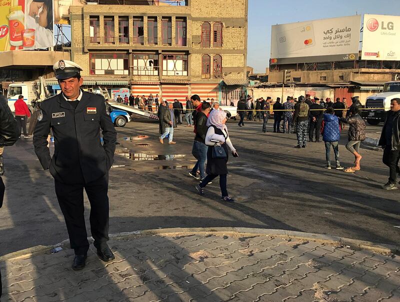 Iraqi security forces and civilians gather at the scene of a double suicide bombing in Baghdad. At least 26 people were killed in the attacks. Ali Abdul Hassan / AP Photo