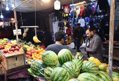 A man talks to a fruit vendor at a market in the southern Iraqi city of Nasiriyah in the Dhi Qar province, on December 20, 2020.  A year of economic agony for pandemic-hit and oil-reliant Iraq is drawing to a close, but a draft 2021 budget involving a hefty currency devaluation could bring more pain for citizens.
Iraq, which relies on oil sales to finance 90 percent of its budget, projects that its economy has shrunk by 11 percent this year, while poverty doubles to 40 percent of the country's 40 million residents. / AFP / Asaad NIAZI
