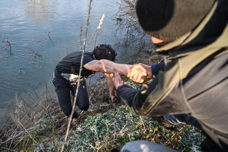 Migrants help each other after an attempt to enter Greece from a location near Edirne, Turkey, by crossing the Maritsa river. AFP