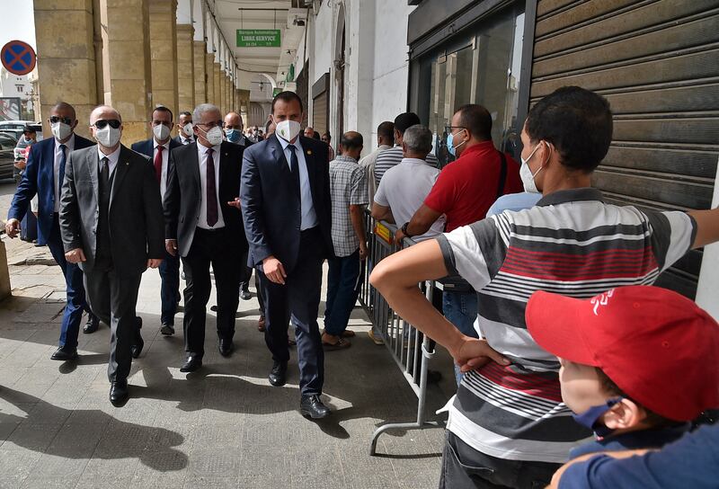 Algerian Prime Minister Aymen Benabderrahmane surrounded by bodyguards outside parliament. AFP