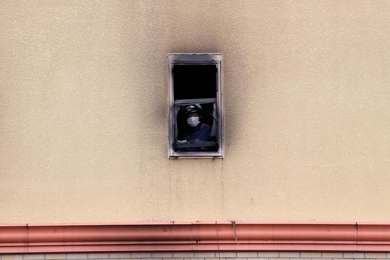 A firefighter looks out of a window at the torched building. Reuters