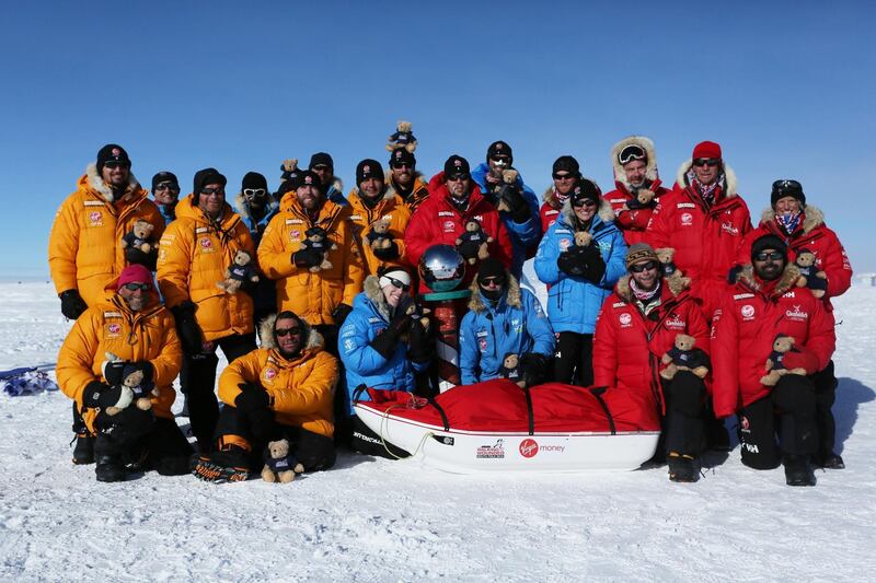 ANTARTICA - DECEMBER 13:  In this handout image provided by Walking with the Wounded, Prince Harry (back row 4th R) poses with members of Team UK, Team Commonwealth and Team US as they reach the South Pole as part of their Walking With The Wounded charity trek on December 13, 2013 in Antartica. The Virgin Money South Pole Allied Challenge 2013, of which Prince Harry is patron, will see the participants race across three degrees to the South Pole. All 12 injured service personnel from Britain, America, Canada and Australia have overcome life-changing injuries and undertaken challenging training programmes to prepare themselves for the conditions they will face in Antarctica. Trekking around 15km to 20km per day, the teams endured temperatures as low as minus 45C and 50mph winds as they pulled their 70kg sleds to the south pole. (Photo by Victoria Nicholson/WWTW via Getty Images) (NOTE TO EDITORS: This handout photo may only be used in for editorial reporting purposes for the contemporaneous illustration of events, things or the people in the image or facts mentioned in the caption. Reuse of the picture may require further permission from the copyright holder.)