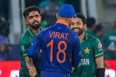 India's captain Virat Kohli (C) congratulates his Pakistan's counterpart Babar Azam (L) and Mohammad Rizwan following their victory during the ICC men’s Twenty20 World Cup cricket match between India and Pakistan at the Dubai International Cricket Stadium in Dubai on October 24, 2021.  (Photo by Aamir QURESHI  /  AFP)