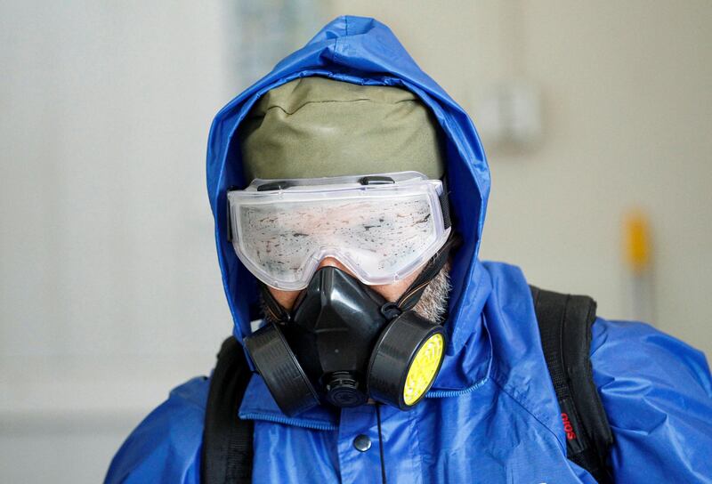 A health worker wearing a protective suit sprays disinfectant outside of a building during an awareness campaign for coronavirus, in Jalalabad, Afghanistan on March 19, 2020. Reuters