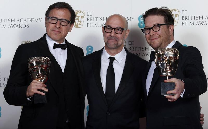 Writers Eric Warren Singer, right, and David O Russell, left, celebrate with actor Stanley Tucci after winning the Original Screenplay category for American Hustle at the Baftas awards ceremony. Suzanne Plunkett / Reuters