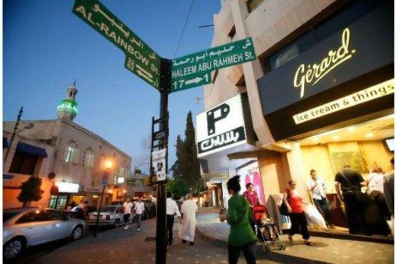 A signpost points to Rainbow Street, famous as a party zone but also home to Jordan's Royal Film Commission. Below, Books@Café is one of Amman's favourite night spots. Salah Malkawi for The National