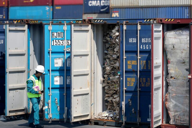 FILE - In this Tuesday, May 28, 2019, file photo, a Malaysian official inspects a container filled with plastic waste shipment prior to sending it to the Westport in Port Klang, Malaysia. The practice of advanced countries such as the U.S., Canada and Japan sending their non-recyclable waste to poorer countries is "grossly unfair" and should stop, Malaysian Prime Minister Mahathir Mohamad said in Tokyo Thursday, May 30, 2019. His comments came days after his government announced plans to return thousands of tons of imported plastic waste back to where it came from. (AP Photo/Vincent Thian, File)