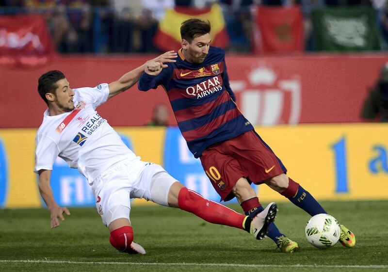 Sevilla's defender Sergio Escudero (L) vies with  Barcelona's Argentinian forward Lionel Messi during the Spanish "Copa del Rey" (King's Cup) final match FC Barcelona vs Sevilla FC at the Vicente Calderon stadium in Madrid on May 22, 2016. (Photo by CRISTINA QUICLER / AFP)