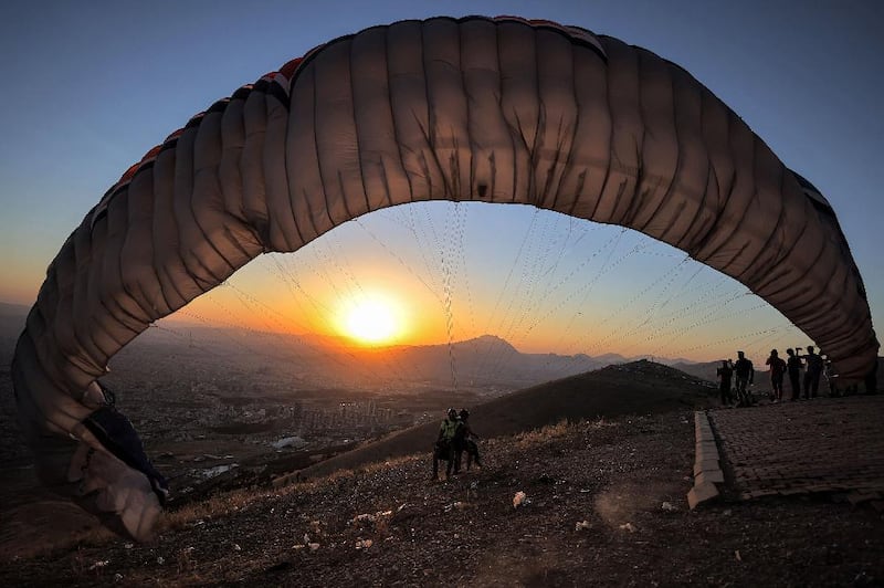 Members of the Sulaymaniyah paragliding team launch at sunset from Mount Azmar to glide over the city of Sulaymaniyah in north-eastern Iraq's autonomous Kurdistan region. All photos: AFP