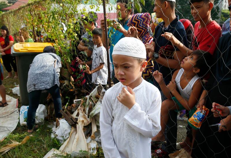 A Muslim boy reacts as Filipinos slaughter goats and cows at the Blue Mosque in Taguig City, east of Manila, Philippines. AP Photo