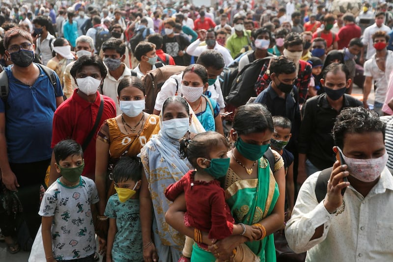 People wearing protective masks stand outside a railway station amidst the spread of the coronavirus disease (COVID-19), in Mumbai, India. Reuters