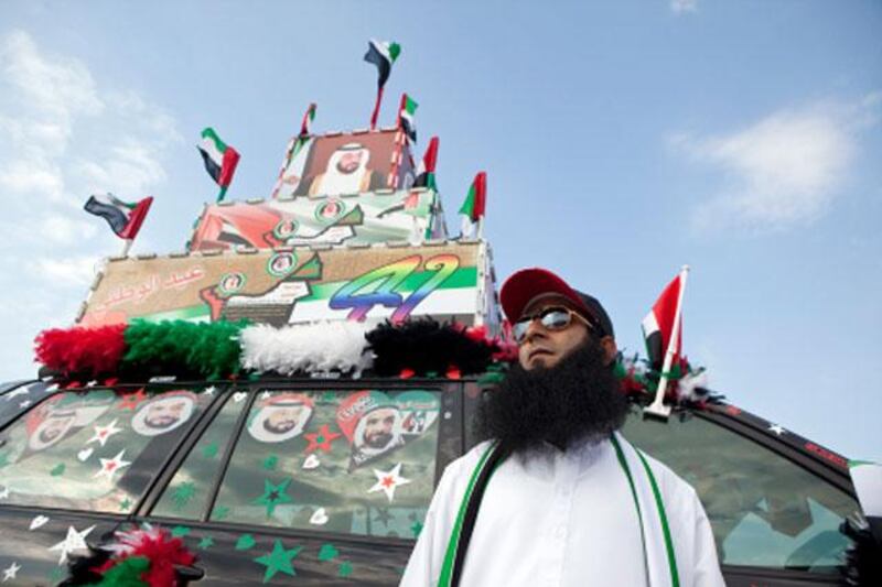 Abu Dhabi, United Arab Emirates, December 02, 2012:  
Ahmad Issa, from Pakistan, poses in front of his decorated car as he and other people celebrate the 41st UAE National Day on Sunday, Dec. 2, 2012, during the Union Car Parade on the Yas Island near Abu Dhabi.  Issa said that it took about a week to get his car properly ready for the day's celebration. Silvia Razgova / The National


