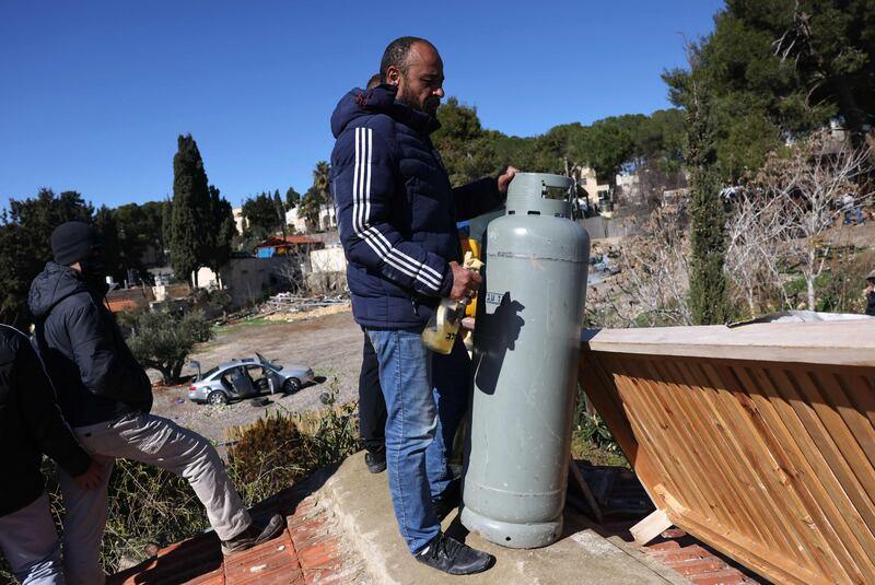 Palestinian resident Mahmoud Salhiyeh hold a gas canister on the rooftop of his home in East Jerusalem's Sheikh Jarrah neighbourhood on January 17. AFP