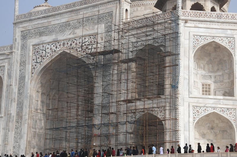 This photograph taken on January 3, 2018 shows tourists visiting the Taj Mahal near scaffolding installed for the conservation work at the monument in the Indian city of Agra.
Restoration work at India's most popular tourist attraction has been dragging on for years, blighting views for tourists, but authorities have not even begun work on the unmissable centrepiece of the 17th-century icon -- its imposing dome. / AFP PHOTO / DOMINIQUE FAGET / TO GO WITH India-conservation-environment-history-Taj,FEATURE by Abhaya Srivastava
