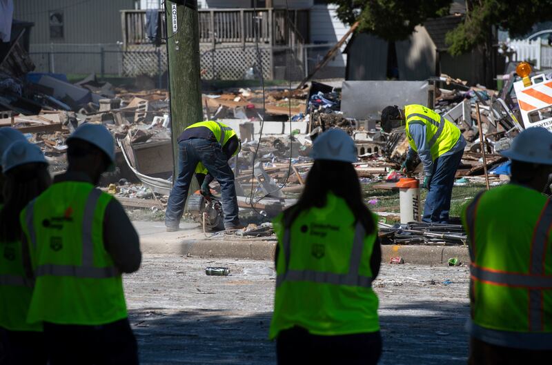 Workers drill a hole in the ground at the site of the explosion. AP