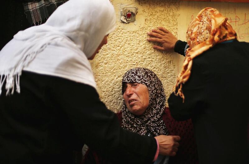 Palestinian relatives of gunman Ahmed Al-Za’anin mourn during his funeral in Beit Hanoun, in the northern Gaza Strip on January 22, 2014. Al-Za’anin and another man were killed Wednesday in an air strike by Israel, which claims one of them fired rockets across the border during former Israeli prime minister Ariel Sharon’s funeral last week. Suhaib Salem / Reuters