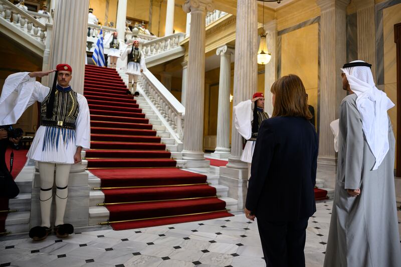 President Sheikh Mohamed and Ms Katerina Sakellaropoulou stand for the UAE and Greek national anthems.