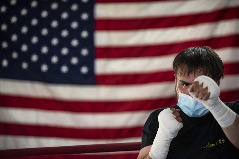 Victor Hernandez shadowboxes while wearing a mask, in front of a US flag hanging on the wall of West Texas Knockout Boxing Club in Odessa, Texas, US.  AP