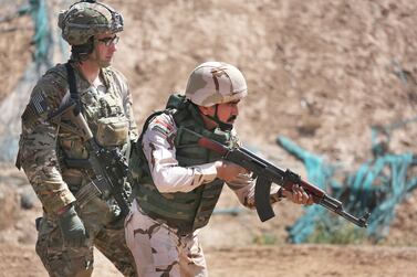 A US army trainer watches as an Iraqi recruit prepares to fire at the Taji military base in Iraq. Getty
