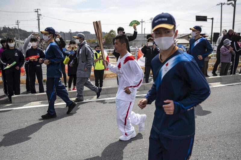Mahiro Abe, a member of Japan's self-defence forces, carries the Olympic torch. AFP