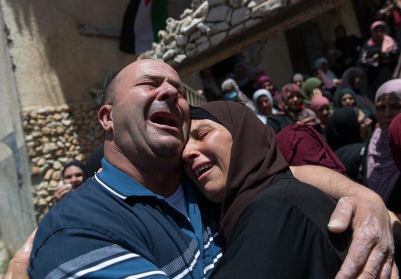 Palestinian mourners cry while taking a last look at the body of Mohammad Daraghmeh at the family house during his funeral in the West Bank village of Lubban, near Nablus, Wednesday, May 12, 2021. Israeli soldiers opened fire yesterday at a Palestinian vehicle at an army checkpoint north of the West Bank, killing Daraghmeh, a passenger, and critically wounding another, the Palestinian health ministry said. (AP Photo/Nasser Nasser)