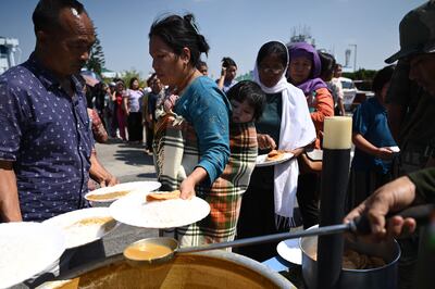 People who have fled Manipur queue for food distributed by the Indian army at Imphal Airport. AFP