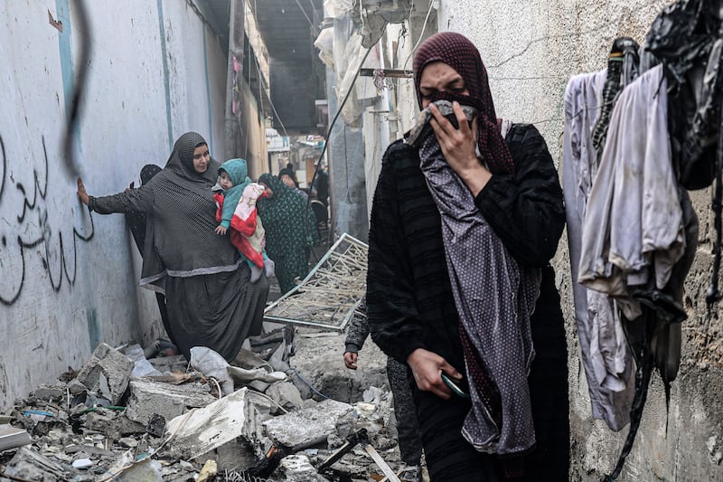 People find their way through a rubble-covered alley, following overnight Israeli bombardment in Rafah in the southern Gaza Strip. AFP