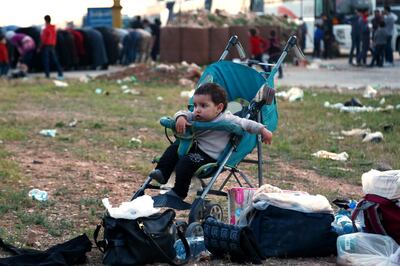 A Syrian child waits in a stroller as buses with Jaish al-Islam fighters and their families on board arrive from their former rebel bastion of Douma in Eastern Ghouta at the Abu al-Zindeen checkpoint controlled by Turkish-backed rebel fighters near the Syrian town of al-Bab in the northern Aleppo province, on April 14, 2018.
The Syrian army on April 14 declared that all anti-regime forces had left Eastern Ghouta, nearly two months into a blistering offensive on the rebel enclave. / AFP PHOTO / Nazeer al-Khatib