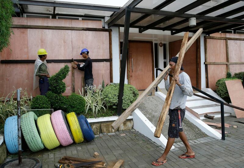 Workers cover the windows of a hotel with sheets of plywood as Typhoon Mangkhut nears Cagayan province, northeastern Philippines. Aaron Favila / AP Photo