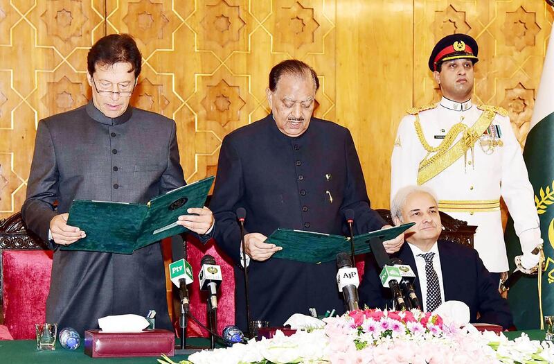 In this handout photograph released by Pakistan's Press Information Department (PID) on August 18, 2018, President of Pakistan Mamnoon Hussain (C) takes an oath from newly appointed Prime Minister Imran Khan (L) during a ceremony in Islamabad, as caretaker Prime Minister of Pakistan Nasirul Mulk (2R) looks on. - Pakistan's new Prime Minister Imran Khan was sworn in at a ceremony in Islamabad on August 18, ushering in a new political era as the World Cup cricket hero officially took the reins of power in the nuclear-armed country. (Photo by Handout / PID / AFP) / RESTRICTED TO EDITORIAL USE - MANDATORY CREDIT "AFP PHOTO / PID" - NO MARKETING NO ADVERTISING CAMPAIGNS - DISTRIBUTED AS A SERVICE TO CLIENTS -