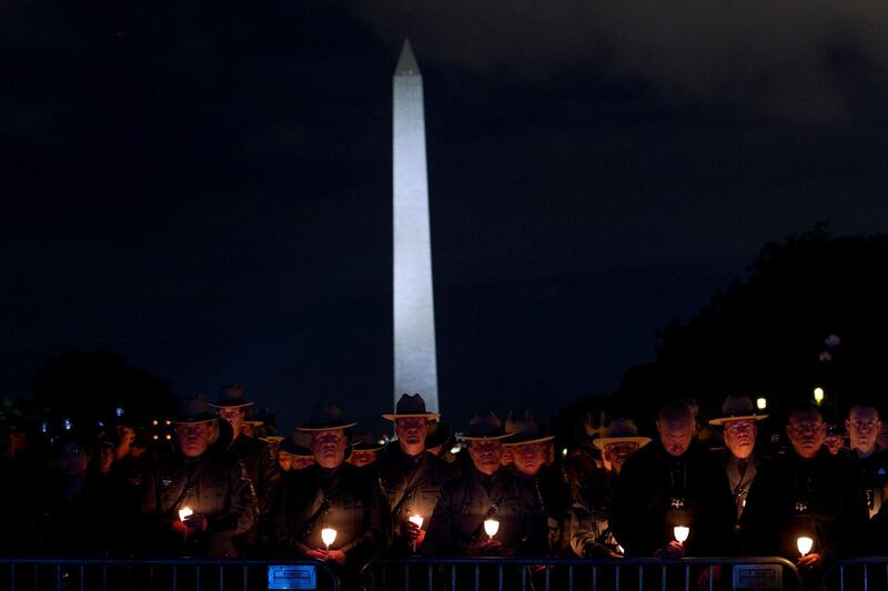 Police officers hold candles in front of the Washington Monument during the National Law Enforcement Officers Memorial Fund Annual Candlelight Vigil to commemorate new names added to the monument, in a ceremony at the National Mall in Washington. AP Photo