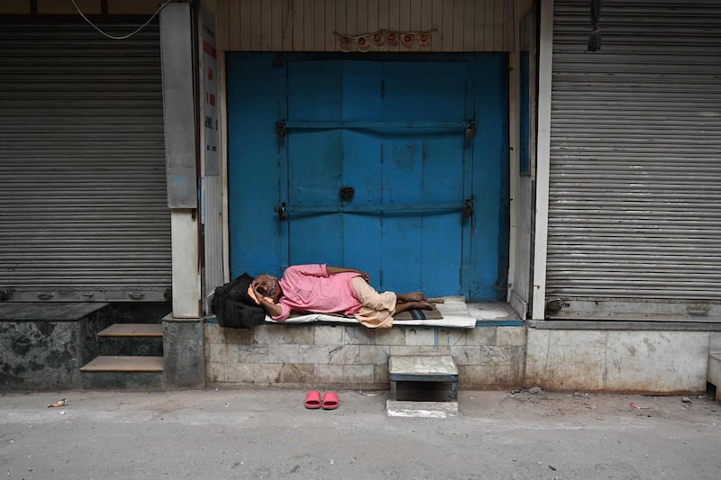 A man takes a nap in front of closed shops in New Delhi, as the Indian capital continues its lockdown in response to the coronavirus pandemic. AFP