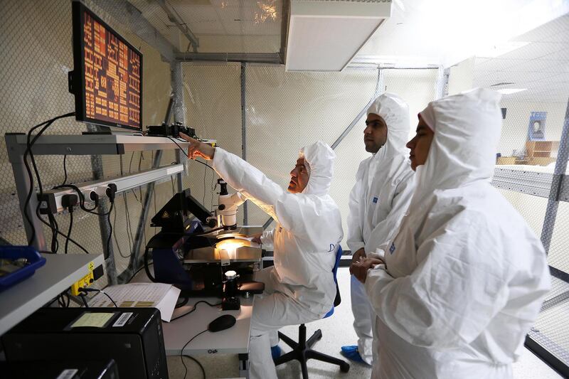 SHARJAH , UNITED ARAB EMIRATES Ð April 6 , 2015 : Lutfi Albasha , Associate Professor , Electrical Engineering  ( center ) with Mansour Taghadosi ( 2nd from right )  and Eiman Elghanam ( 1st from right ) students of Electrical Engineering doing research on energy harvesting in the clean room at Microwave Imaging and Nondestructive Evaluation Laboratory at American University of Sharjah in Sharjah. ( Pawan Singh / The National ) For News. Story by Melanie Swan
 *** Local Caption ***  PS0604- AUS RESEARCH03.jpg