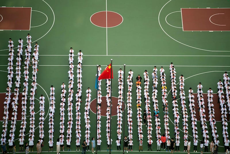Children line up for a flag-raising ceremony on their first day back to school at a middle school in Shanghai, China. Johannes Eisele / AFP