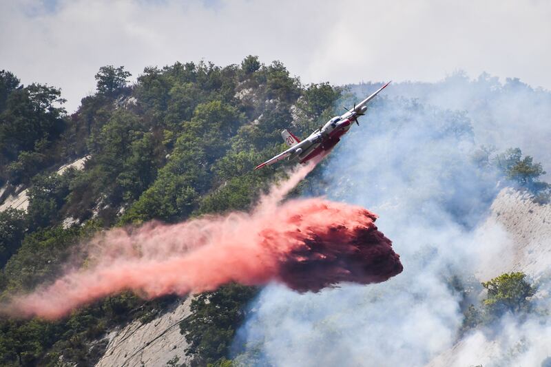 A firefighting aircraft drops flame retardant to put out a fire in Rigaud, north of Nice, southeastern France, on August 3, 2017.
France has been battling for several weeks huge fires near beaches popular with tourists on the Cote d'Azur, forcing the evacuation of people. / AFP PHOTO / Yann COATSALIOU